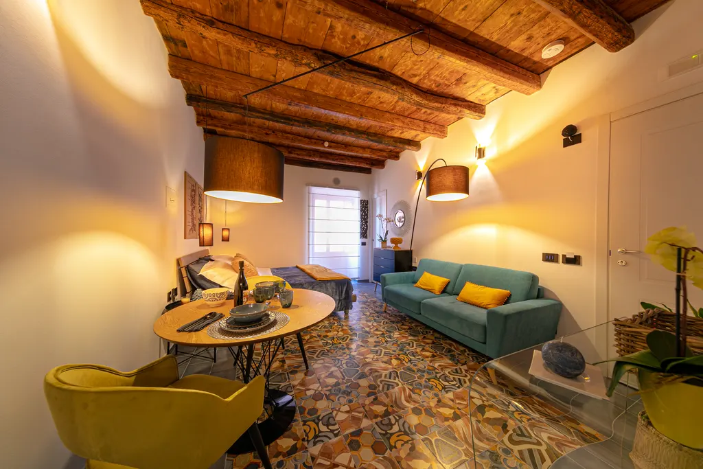 L'interno di Mont°6 con travi a vista, maioliche e divano